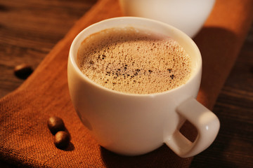 Cup of coffee on napkin on table close up