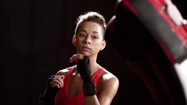 Black Woman kickboxing with trainer