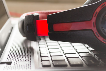 Black and red headphones placed over a laptop's keyboard