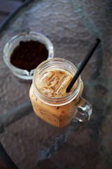 Ice coffee and coffee ground in a ashtray on table
