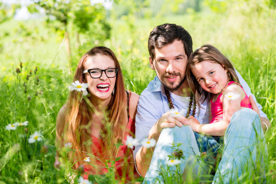 Familie isst auf Wiese im Sommer Gras beim Pickick