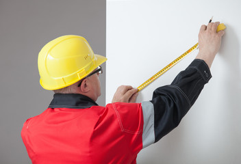 Man in the yellow hard hat determining the distance