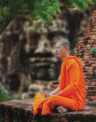 Fototapeta premium Angkor Wat monk. Ta Prohm Khmer ancient Buddhist temple in jungle forest. Famous landmark, place of worship and popular tourist travel destination in Asia