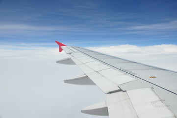 Fototapeta premium View from airplane window with blue sky and white clouds