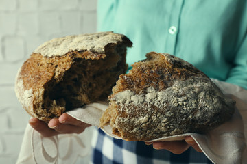 Woman holding tasty fresh bread, close up