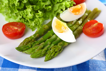 Plate of dietary salad with boiled asparagus and egg, closeup