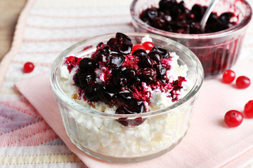 Cottage cheese with black canned currant on napkin table, closeup