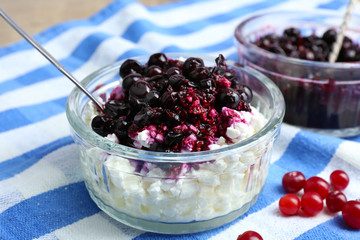 Cottage cheese with black canned currant on striped napkin, closeup