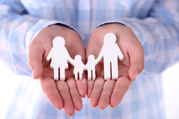 Female hands holding toy family, closeup