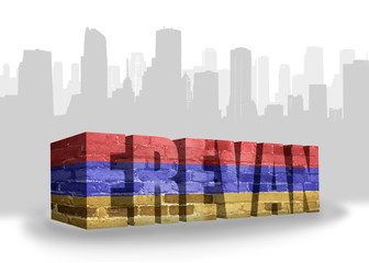 Fototapeta premium text yerevan with national flag of armenia near abstract silhouette of the city