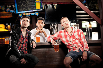 Watching TV in bar. men drinking beer sitting  bar