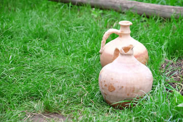 Old clay jugs on green grass background