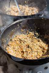 street food hot pilaw in cauldron on oven