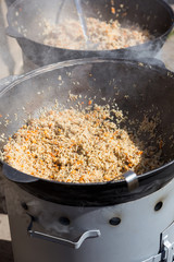 street food hot pilaw in cauldron on oven