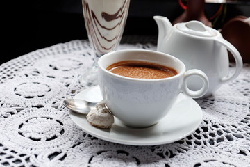 Hot chocolate in mug, on table, on dark background