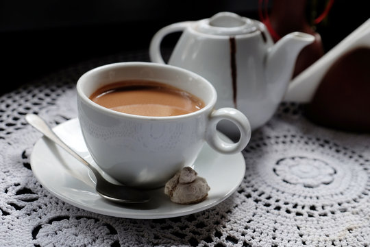Hot chocolate in mug, on table, on dark background