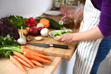 Young woman cutting vegetables in the kitchen