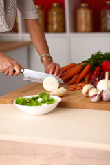 Young woman cutting vegetables in the kitchen