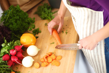 Young woman cutting vegetables in the kitchen