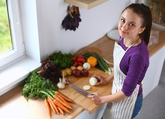 Young woman cutting vegetables in the kitchen