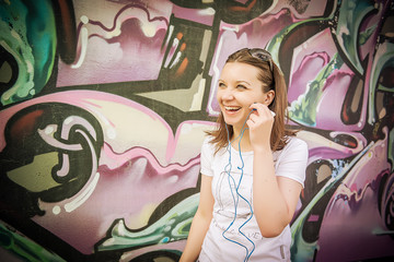 Fototapeta na wymiar girl in sunglasses near graffiti wall