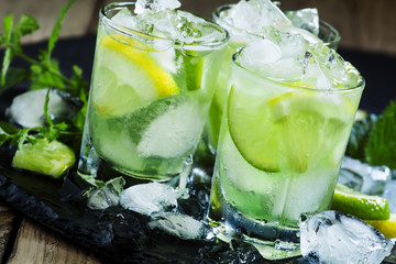 Lemon-lime green drink with crushed ice on a dark background, se