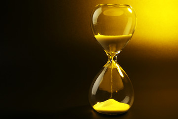 Hourglass on dark yellow background