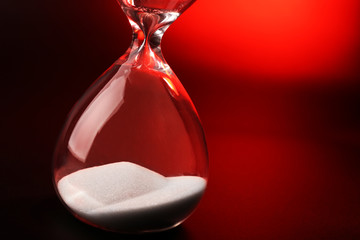 Hourglass on dark red background