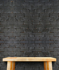 Blank modern wooden table with leg at black brick wall ,Template