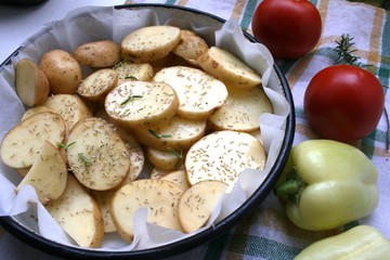 Raw and sliced potatoes with rosemary