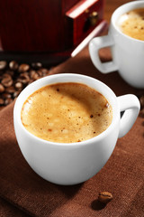 Obraz premium Two cups of fresh coffee with beans on table, closeup