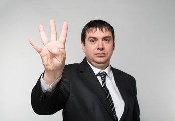 Portrait of a businessman showing four fingers