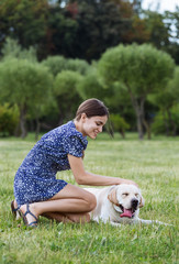 Portrait of a beautiful woman sitting on the grass with a playfu