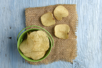 Potato chips on old wooden table