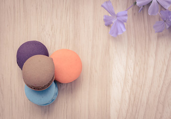 Colorful French macarons on wooden background in vintage filter color style