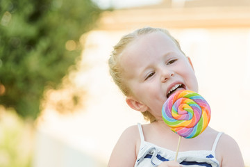 Beautiful blonde girl-tasting colored lollipop