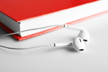 Earphones and book on table, closeup