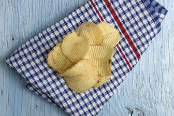 Potato chips on old wooden table