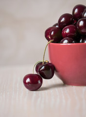 Cherry in a cup on the wooden table