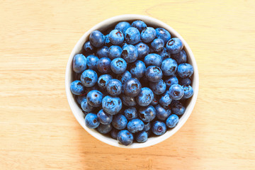 Blueberries in the ceramic bowl on the wood