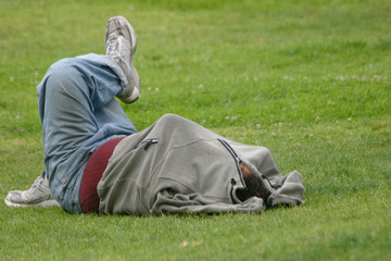 Homeless man sleeping in the Grass.