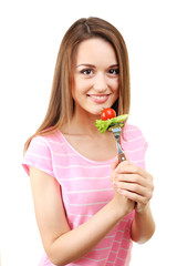 Healthy young woman with vegetables on fork isolated on white