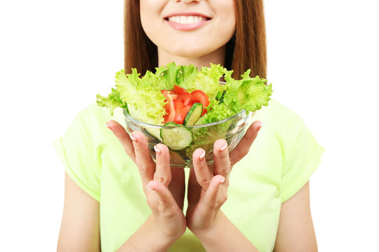 Young woman with glass bowl of diet salad isolated on white