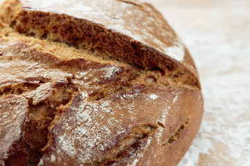 Rye bread on a wooden board sprinkled with flour