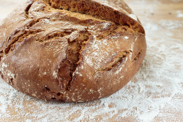 Rye bread on a wooden board sprinkled with flour