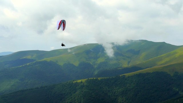 4k,
Paraglider flying high in the mountains

