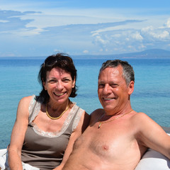 Fototapeta premium Loving couple on holiday at a beach bar by the transparent turqu
