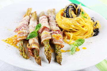 Dish of asparagus, bacon and pasta in plate on table, closeup