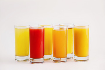 Full colorful glasses of juice isolated at white background