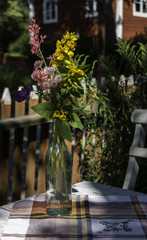 Summer flowers in glass bottle